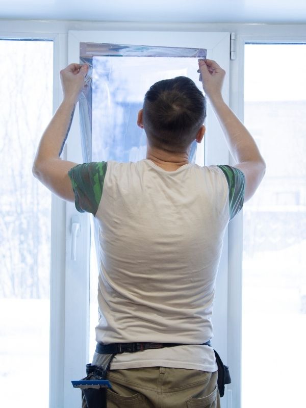 A technician installing heat-reducing window film. 